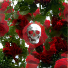 Skull with red roses and green foliage on white background