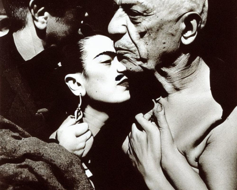 Monochrome image of woman kissed by bald man with another man in background