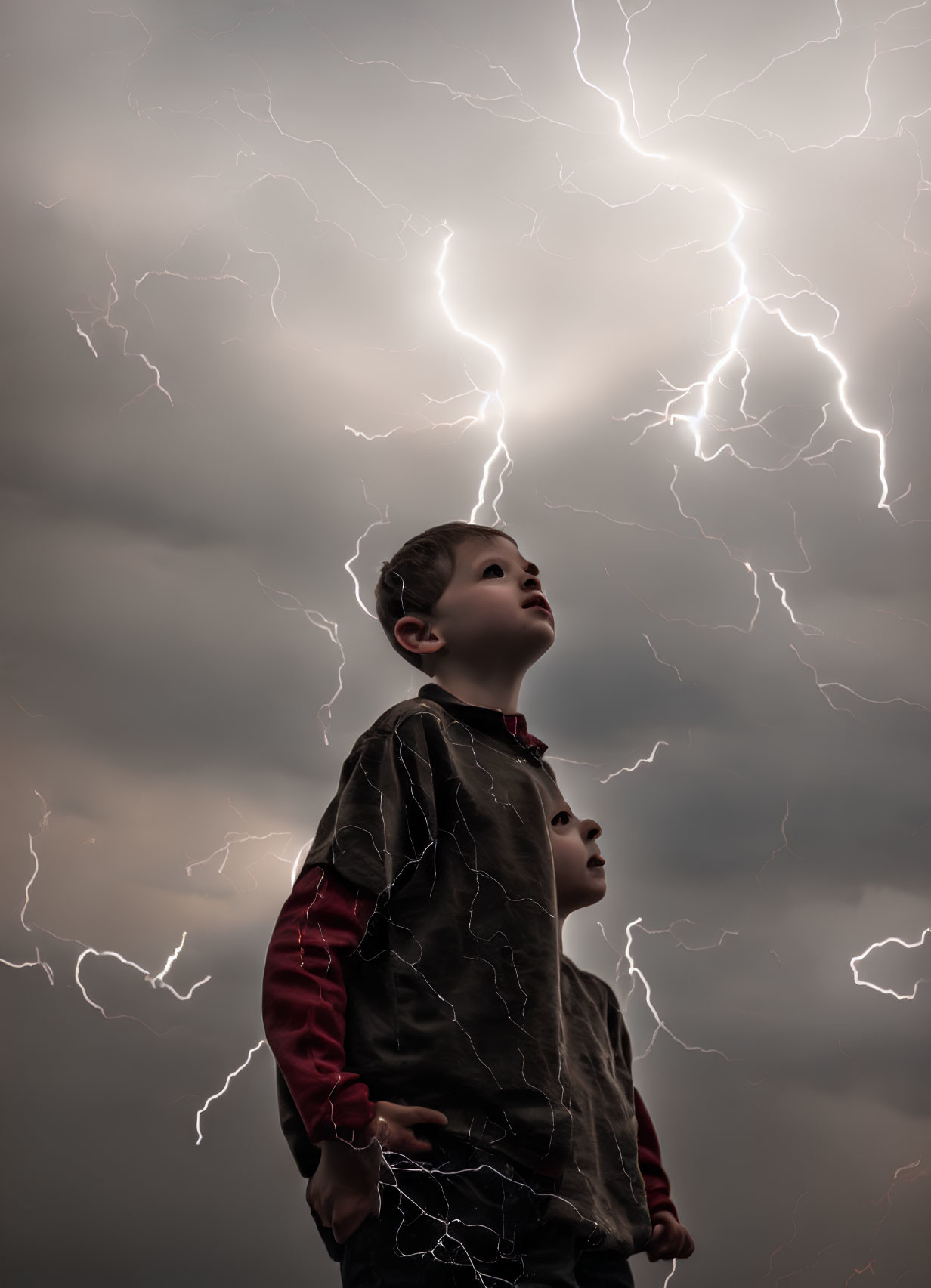 Child gazes at dramatic sky with forking lightning