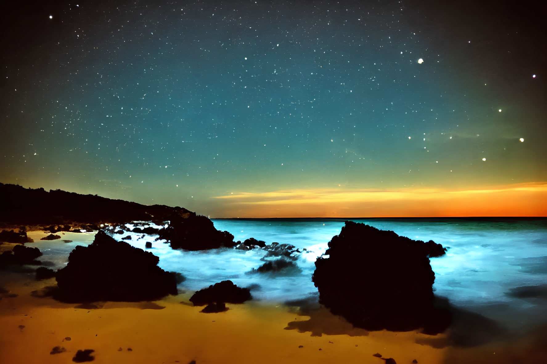 Serene beach scene with starry night sky and warm sunset glow