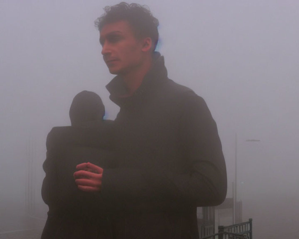 Person in dense fog wearing warm jacket and looking contemplative.