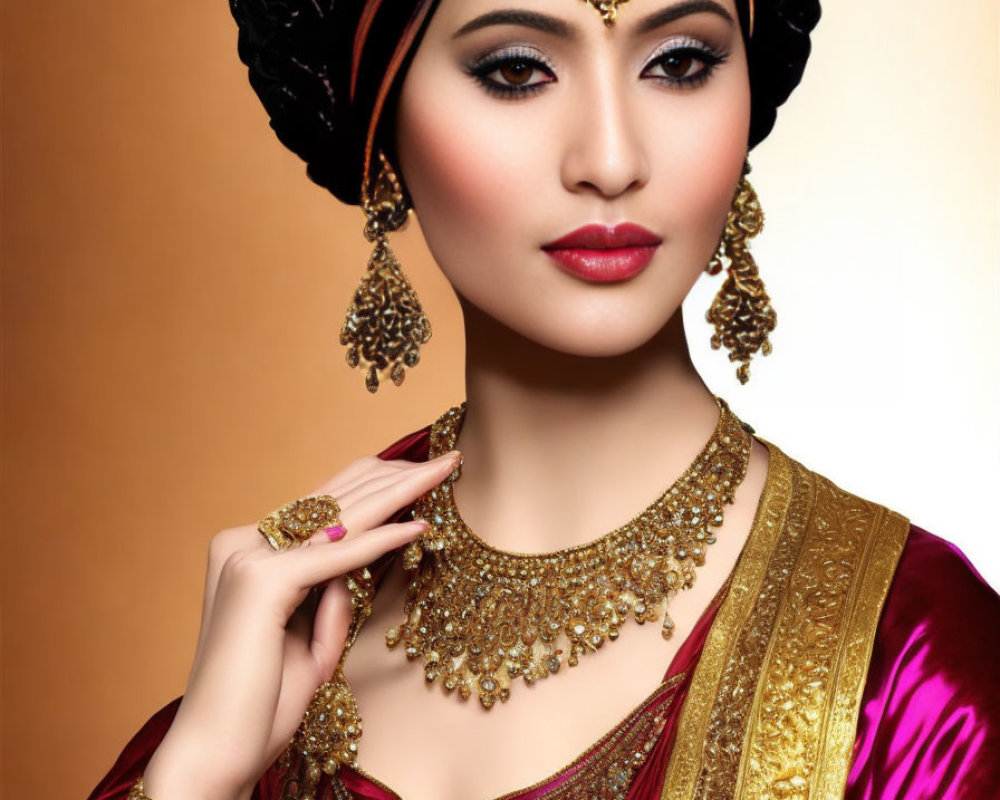 Intricately adorned woman in gold jewelry and burgundy outfit on beige background