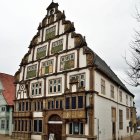 Half-Timbered House with Pointed Roof and Flowers in Old-Fashioned Village Street