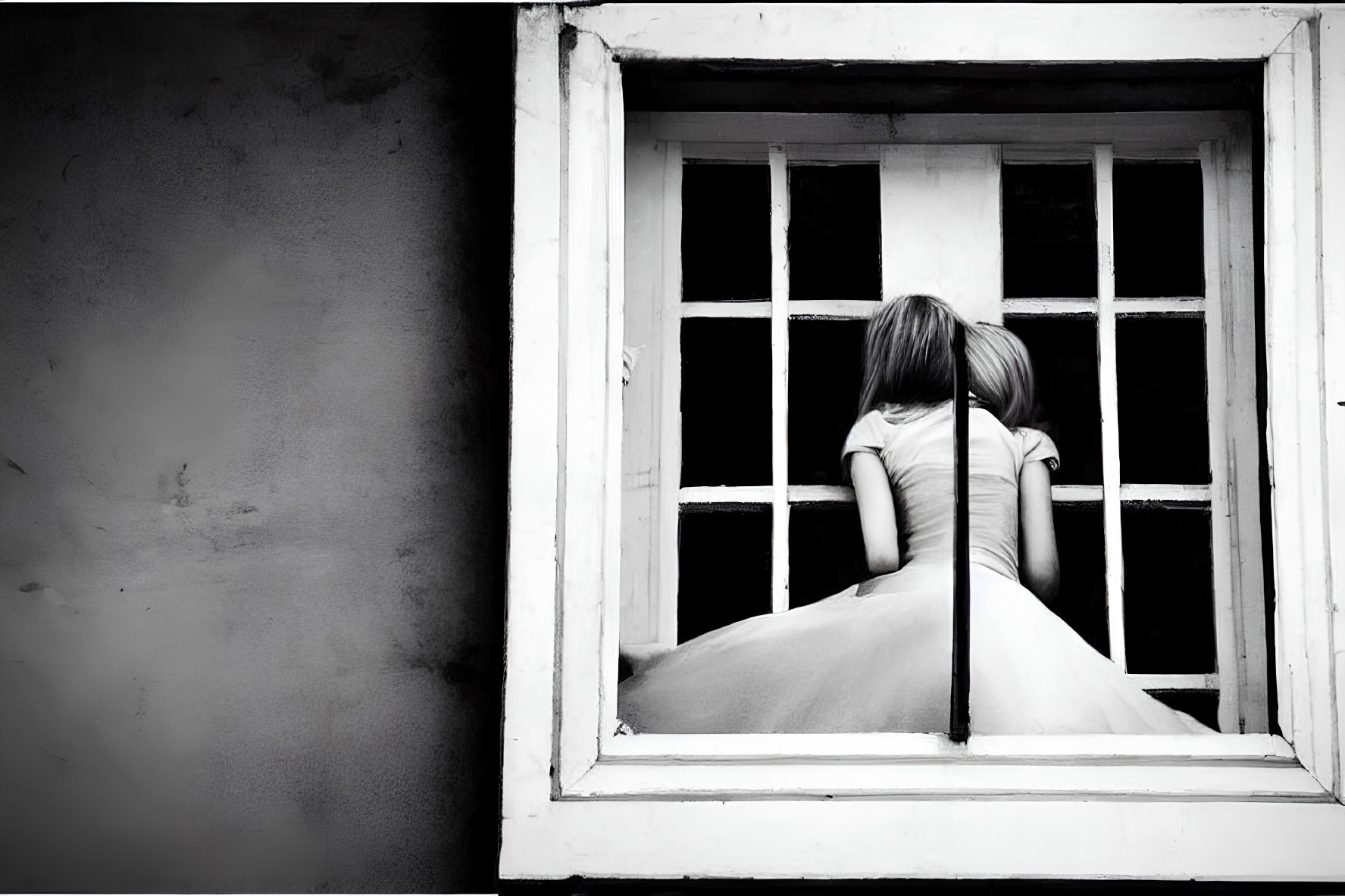 Monochrome photo of person in dress by window, back turned