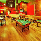 Vintage Pool Hall Painting with Reddish-Orange Walls & Green Tables