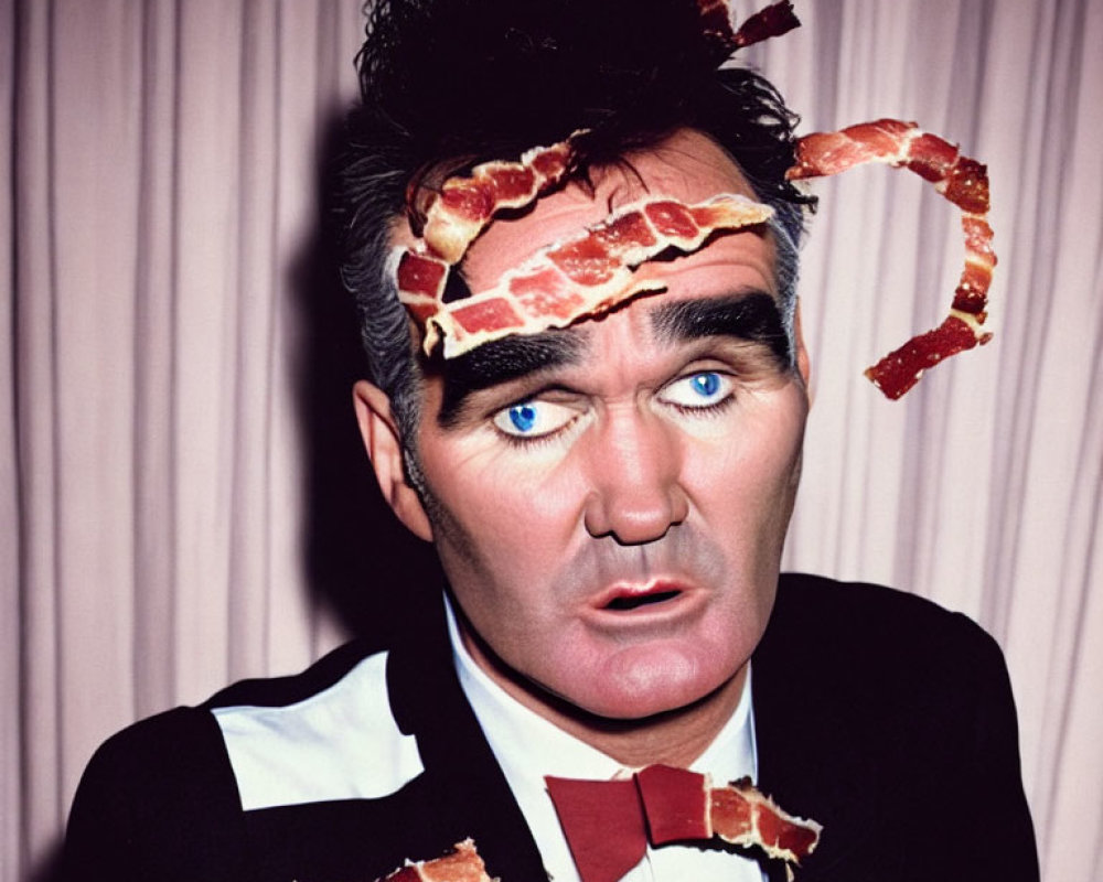 Man with Dark Hair and Bow Tie Balancing Bacon Strips on Head