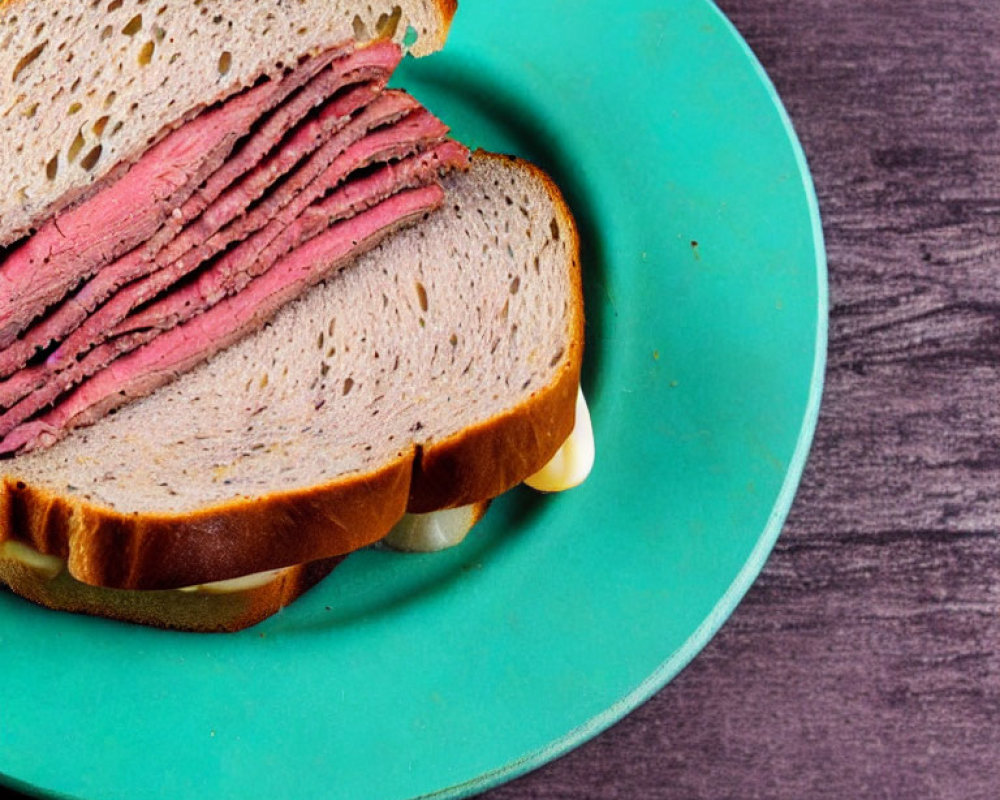 Pastrami and Cheese Sandwich on Turquoise Plate with Dark Wooden Background