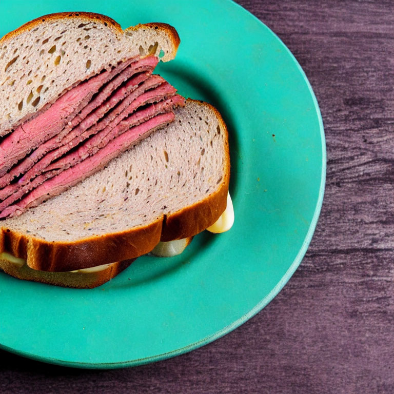 Pastrami and Cheese Sandwich on Turquoise Plate with Dark Wooden Background